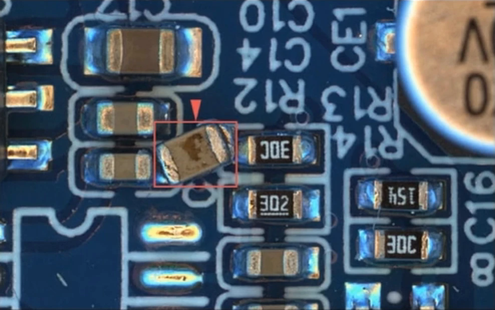 A dropped chip component lying across other parts, flagged as a foreign object